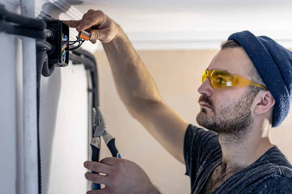 Elektriker schließt Leitungen in einer Abzweigdose an
